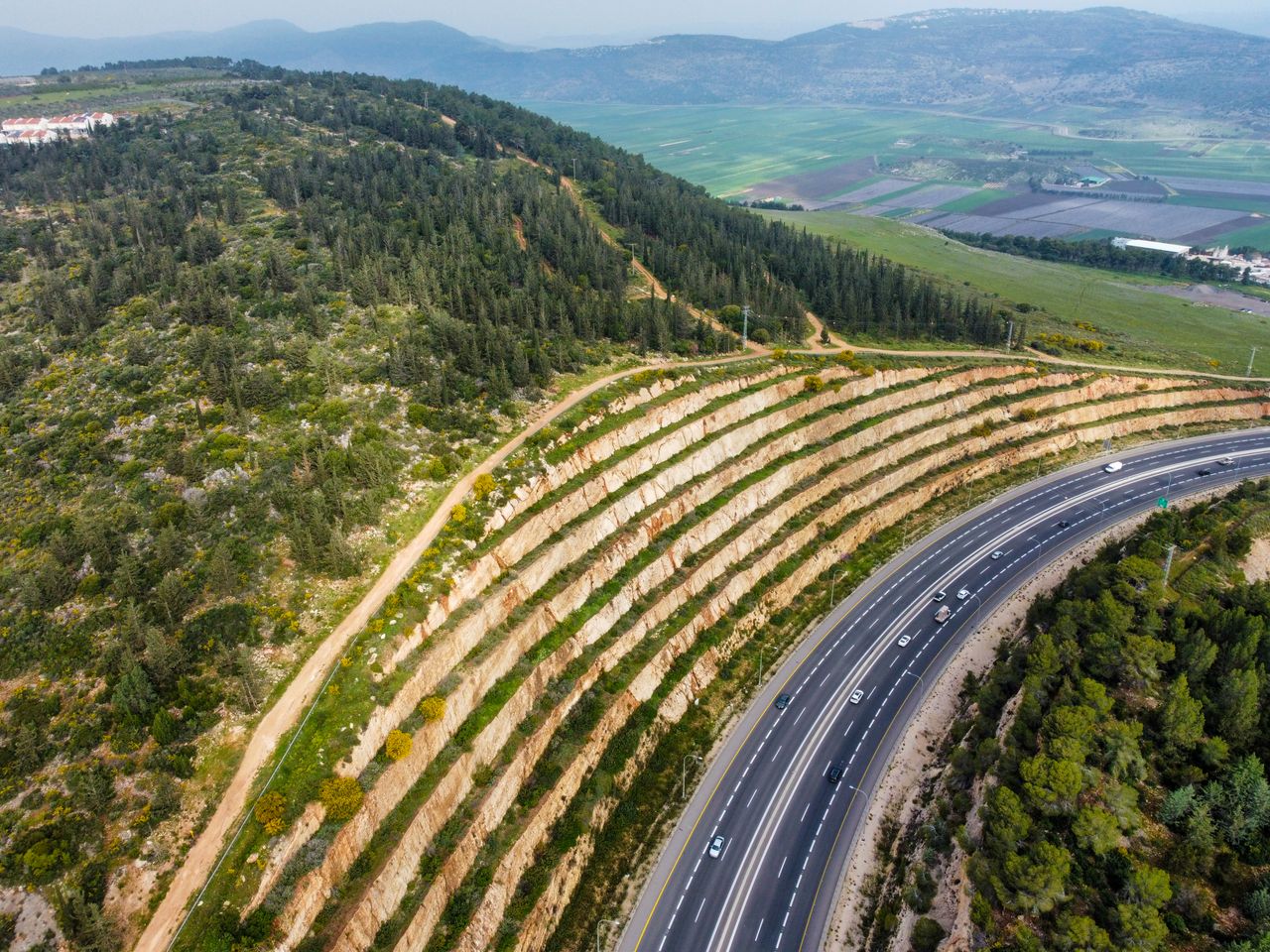 Vista aérea de rodovia com talude tratado — inclinação e gramatura de biomanta